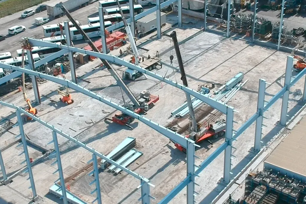 Estructura metálica en obra tradicional con grúas